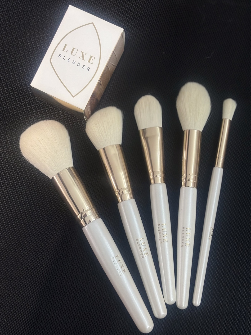 Set of makeup brushes with Luxe Blender packaging on a black background